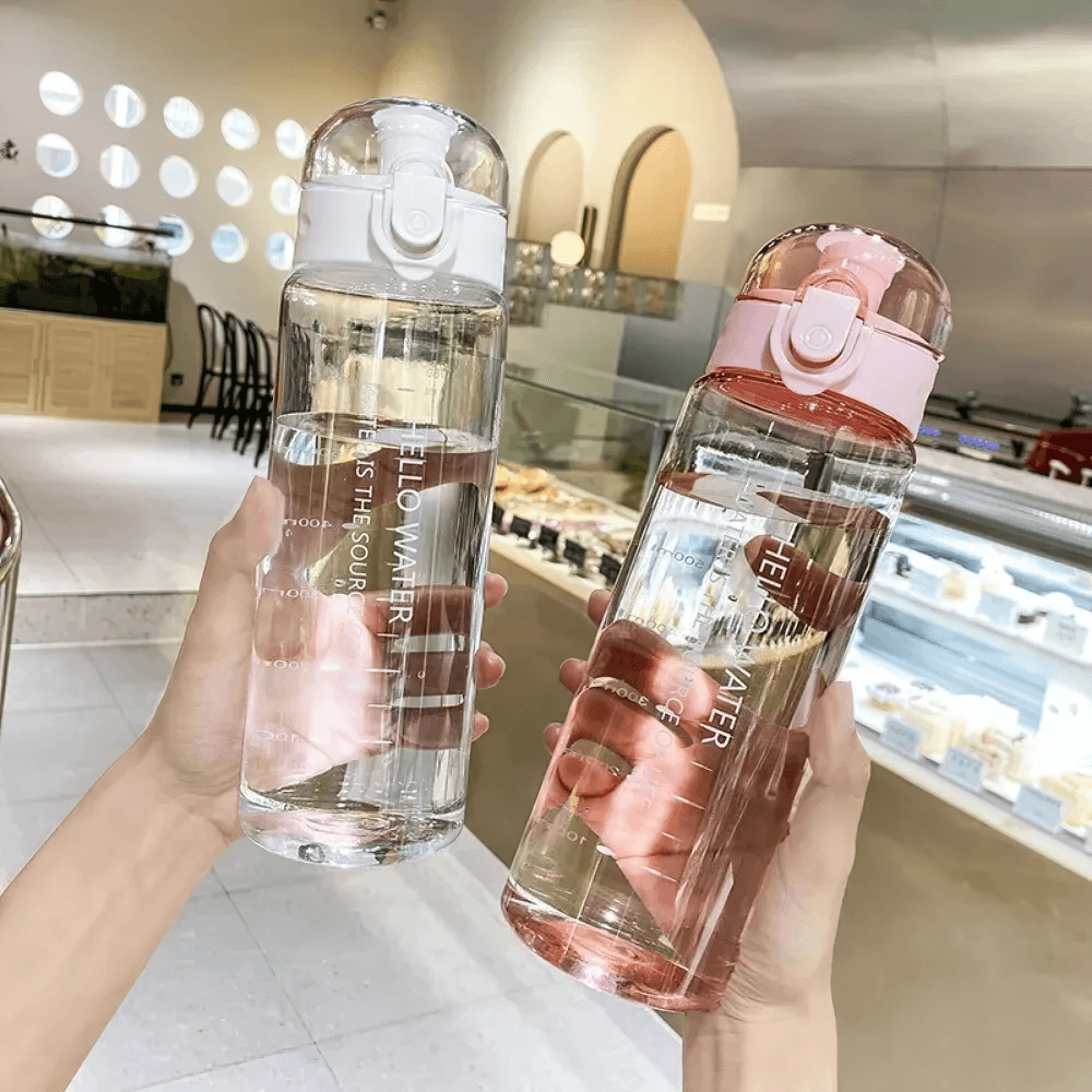 Hands holding two reusable water bottles with time markers, perfect for on-the-go hydration and eco-friendly living.